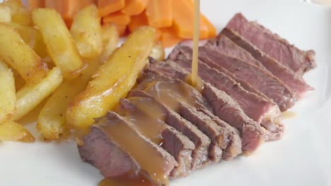 Close-Slow-Motion-Slider-Shot-of-Pouring-Sauce-on-a-Steak-Dinner