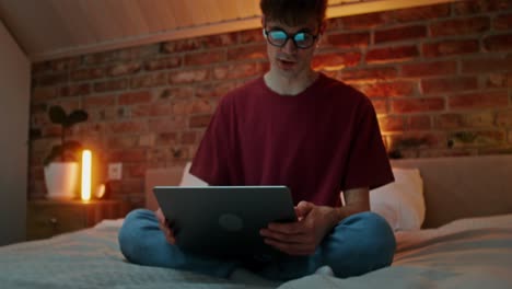 young man studying late at night in bedroom