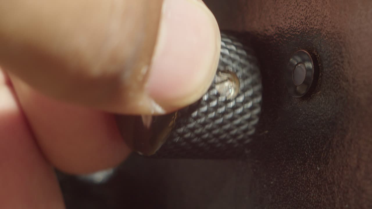 Macro abstract motion of a finger turning a metallic gear. Suggests concepts like industry, innovation, or precision