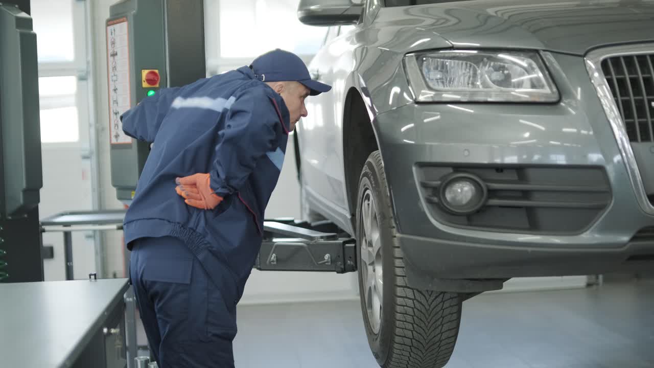 mecánico de automóviles inspeccionando un suv levantado