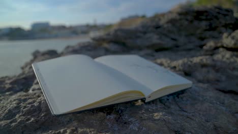 Sketching-by-the-Coastal-Rocks,-Sketchbook-kept-on-the-rocks-next-to-the-sea