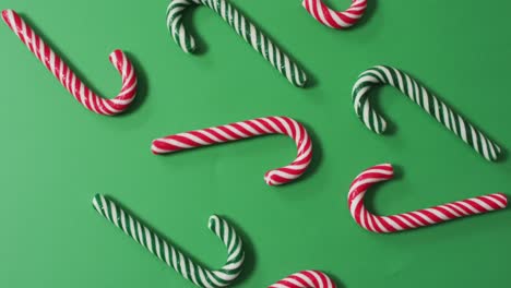 red and green striped candy canes on green background