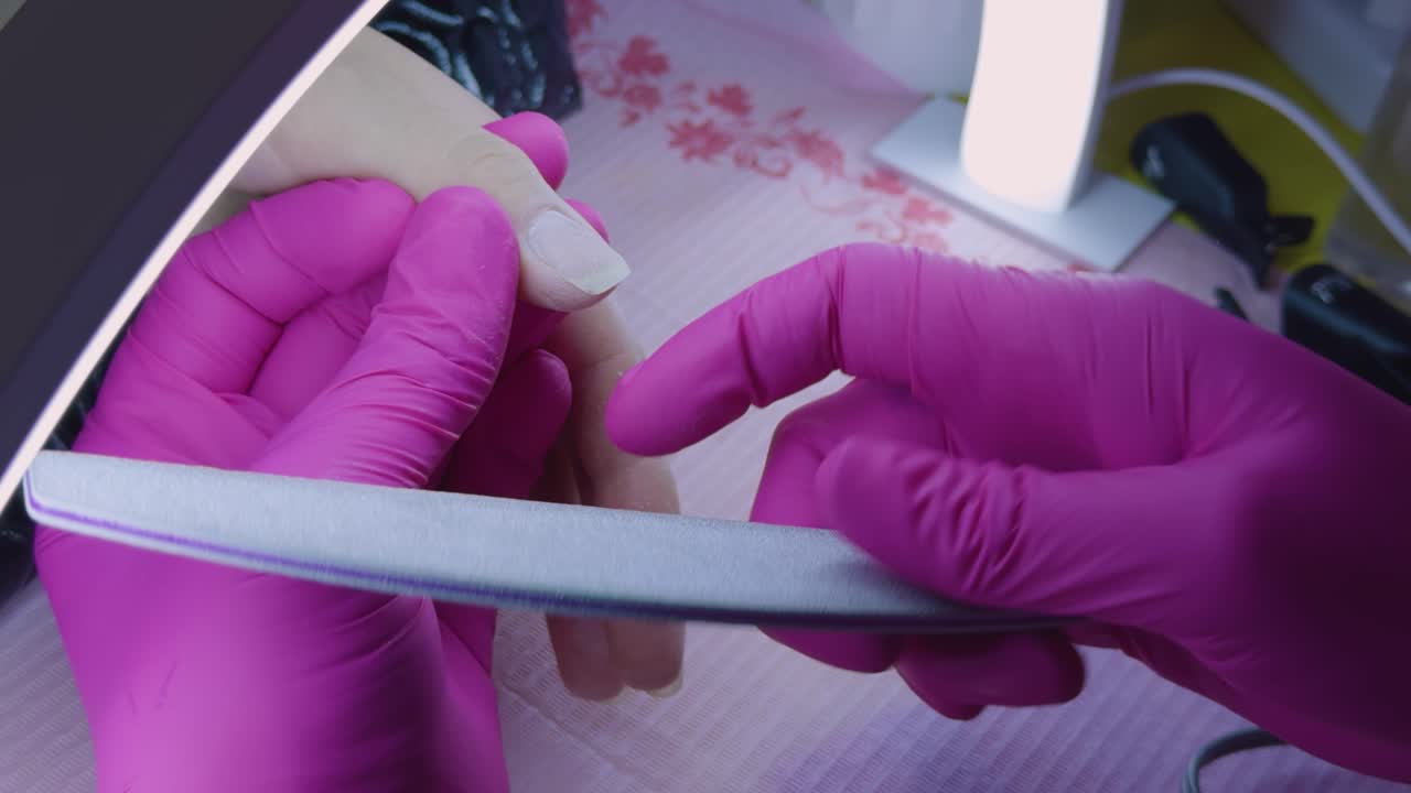 Manicurist filing her client's nails at home. Home care, entrepreneurship, entrepreneur