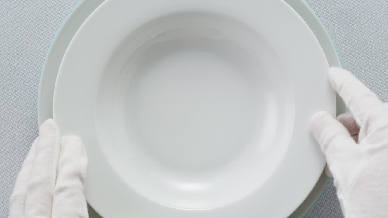 Elegant table setting with white tableware plates, cutlery, and glassware for a classy dining, fancy expensive restaurant dinner
