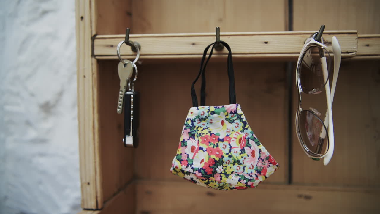 Anonymous hand grabbing keys, fashion face mask and sunglasses when leaving the house during coronavirus pandemic