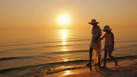 Summer-Vacation-With-A-Child---A-Woman-With-Her-Daughter-Strolling-Along-The-Seashore-At-Sunset-Stea