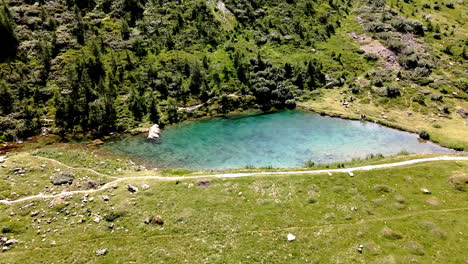 movimiento circular de vista aérea girando alrededor de un lago de montaña de agua turquesa clara en el verano