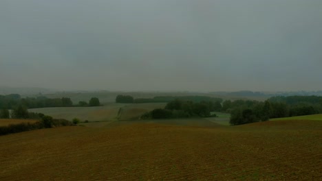 Aerial-footage-over-filed-during-foggy-morning,-Cloudy-sky-and-natural-landscape-around,-drone-4K,-warmia-and-masuria,-Poland