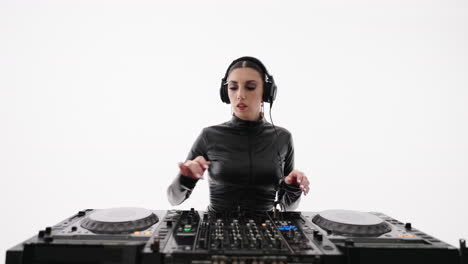 a woman wearing headphones is mixing music on a dj mixer.