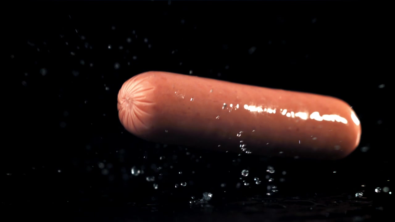 Salsiccia che cade e schizza acqua al rallentatore.