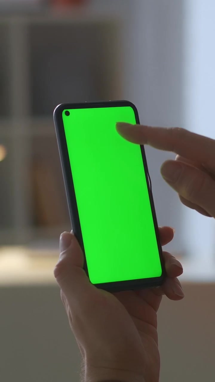 Primo piano di mani che scorrono e toccano su uno smartphone con schermo verde
