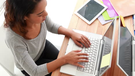 Casual-businesswoman-working-on-laptop-at-office