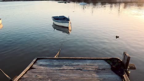 tilt up shot of boat anchored near wooden dock in river, barbate, spain