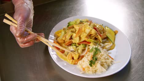 chef placing prawn atop udon: chinese dish preparation