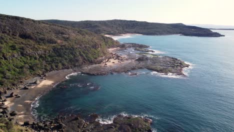 drone aerial landscape scenery pan shot over rocky headland reef frazer beach lake munmorah national park ocean tourism travel central coast nsw australia 4k