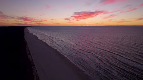 Vista-Aérea-De-La-Hermosa-Playa-En-Krynica-Morska-Durante-La-Puesta-De-Sol-Dorada-En-El-Horizonte---Olas-Tranquilas-Del-Mar-Báltico-Que-Llegan-A-La-Costa