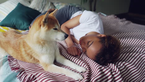 woman and dog sleeping on bed