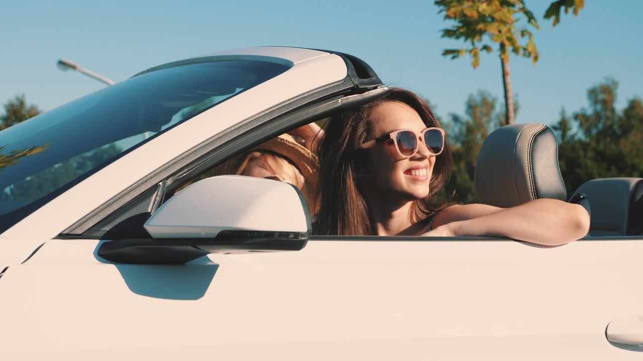 dos mujeres disfrutando de un viaje por carretera en un descapotable