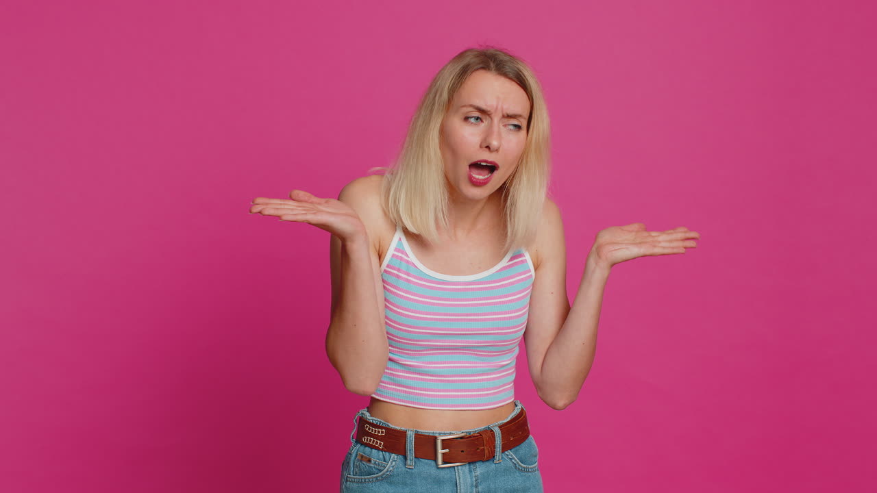 Caucasian woman trying hear you looking confused and frowning keeping arm near ear for louder voice