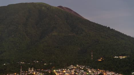 views of a town nestled at the base of a volcanic mountain