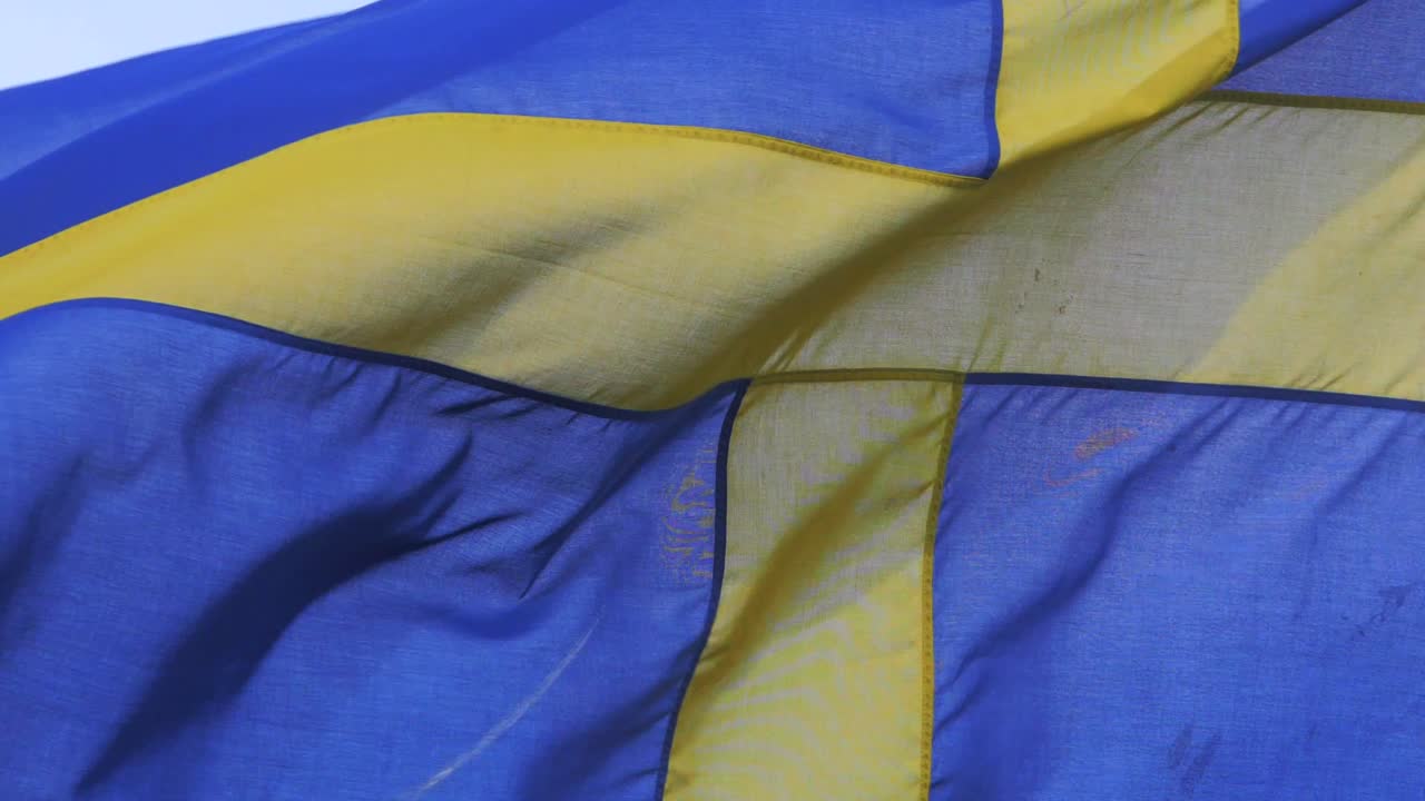 The Swedish flag waving proud in heavy wind. Patriotic themed concept.