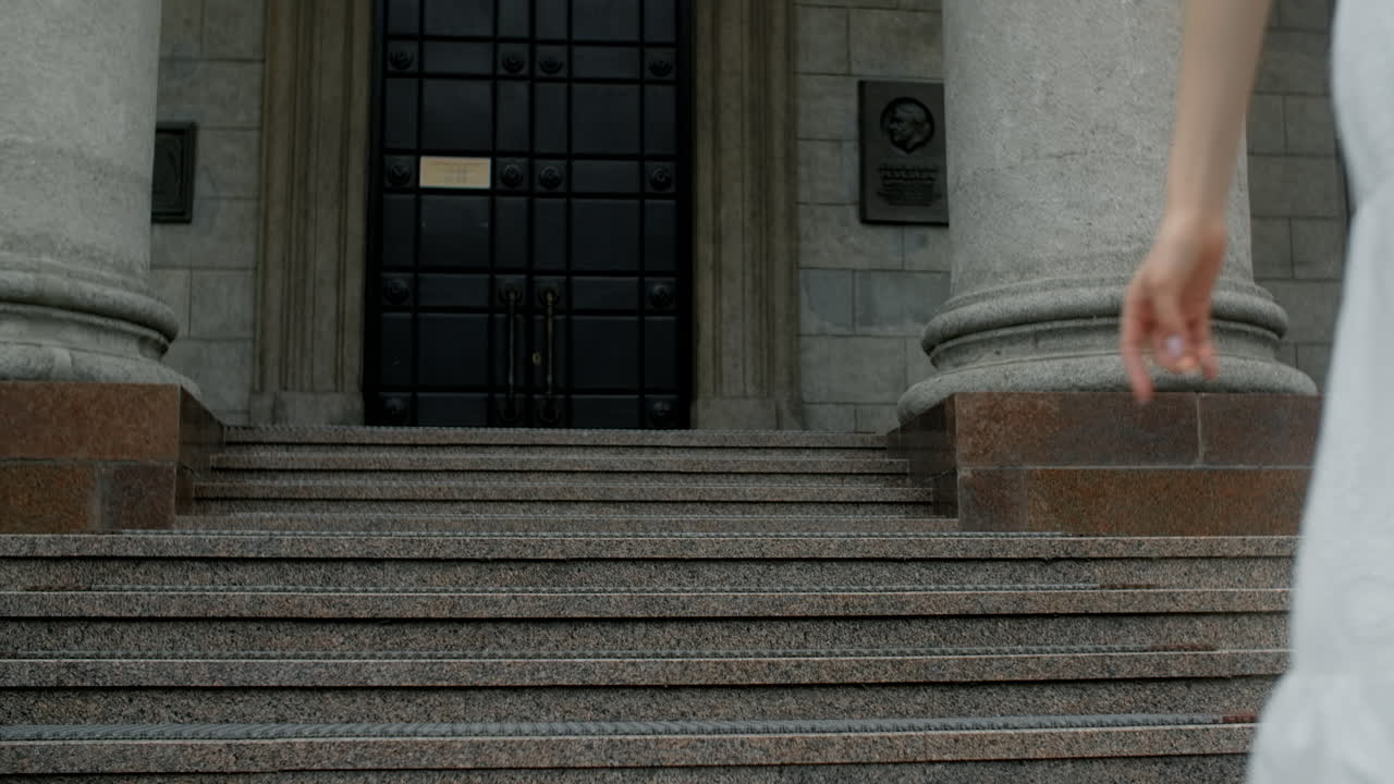 Woman in a white dress on the steps of a historical building