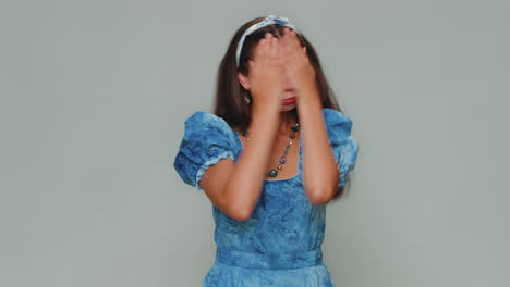 pretty young woman closing eyes with hand showing stop gesture, confused shy scared to watch, awful