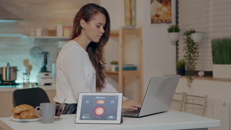 mujer remota trabajando en una casa moderna dando comandos de voz a la tableta