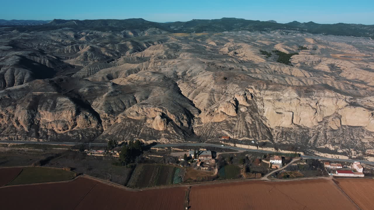 vista aérea de un paisaje seco y montañoso con tierras de cultivo y carreteras