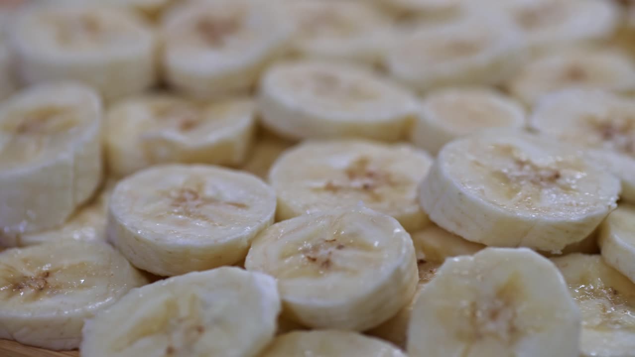 A close-up view of freshly sliced bananas spinning on a wooden surface.