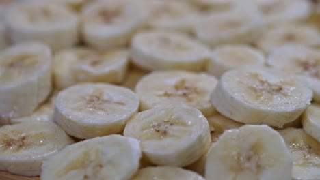 a close-up view of freshly sliced bananas spinning on a wooden surface.