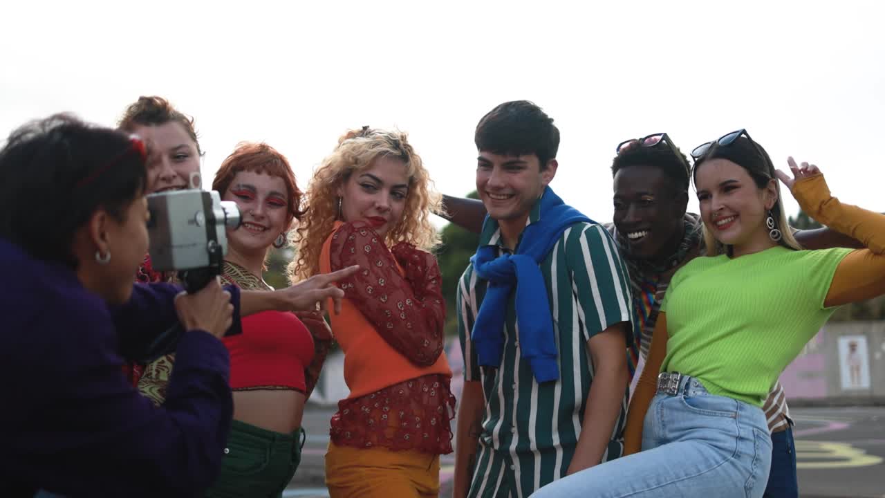 다양한 젊은이들이 오래된 빈티지 비디오 카메라를 가지고 야외에서 즐기고 있습니다.