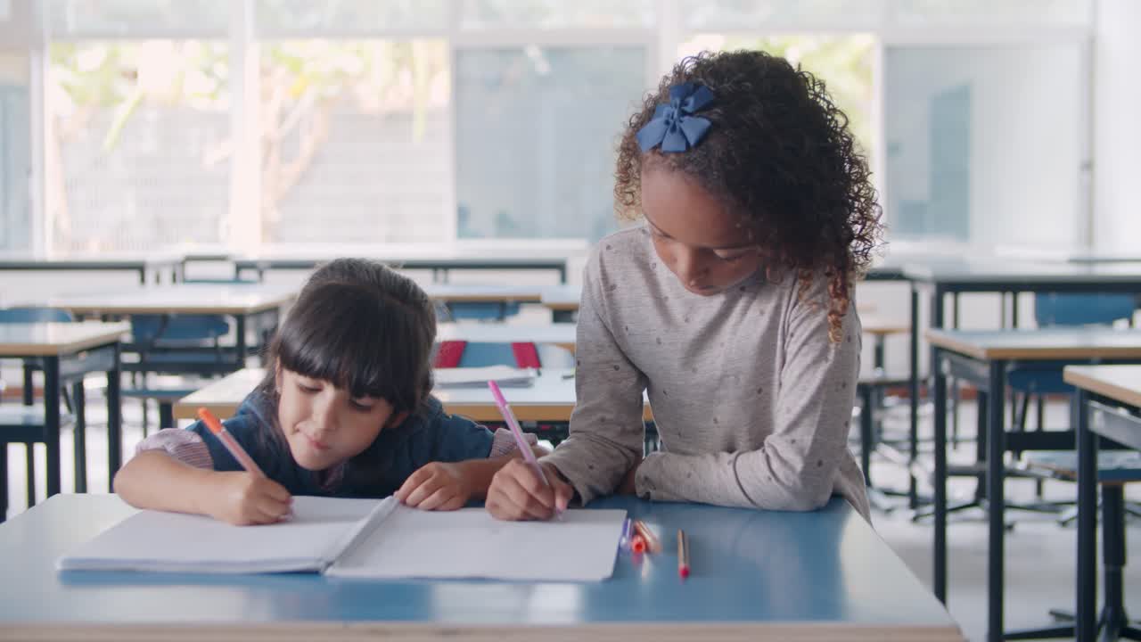 Focused Black and Latin primary school pupil girls drawing