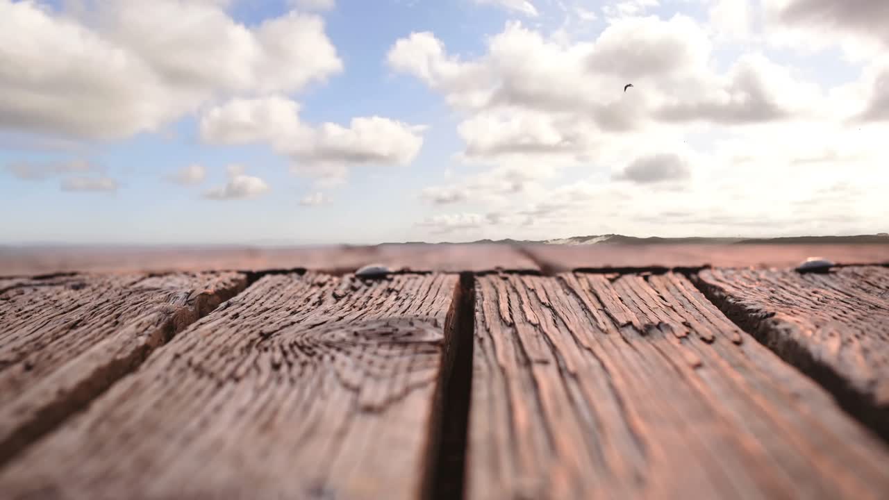 pájaro volando en el cielo con una vista de una tabla de madera