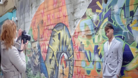 photographer taking photo of a model in front of a graffiti wall