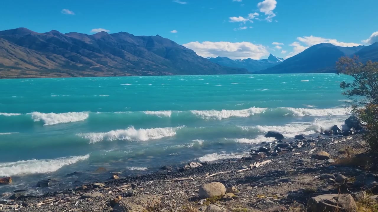 Le acque turchesi del Lago Argentino si estendono attraverso la natura selvaggia della Patagonia vicino a Puerto Bandera, Argentina, con coste frastagliate e vasti paesaggi aperti in una giornata ventosa