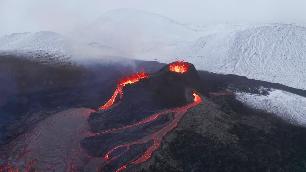 Veduta aerea intorno a fontane di lava vulcanica, nel mezzo di una natura innevata - ripresa in orbita con drone