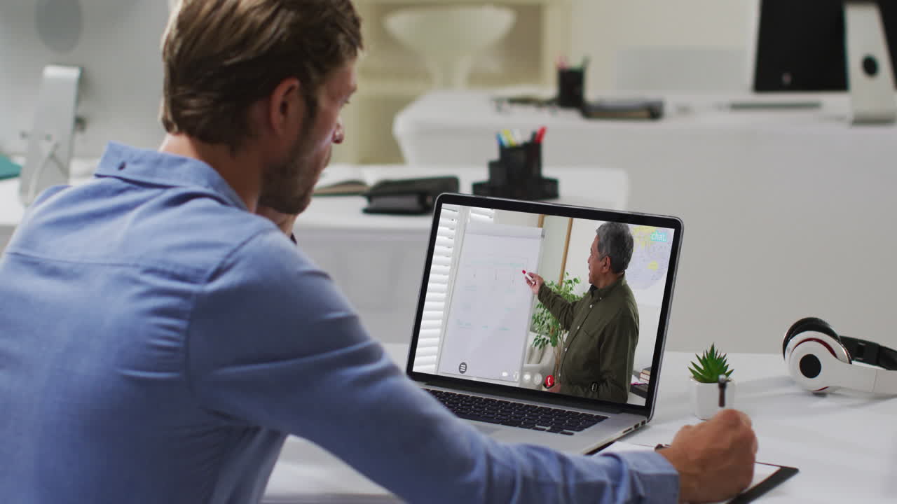 Caucasian male student using laptop on video call with male teacher