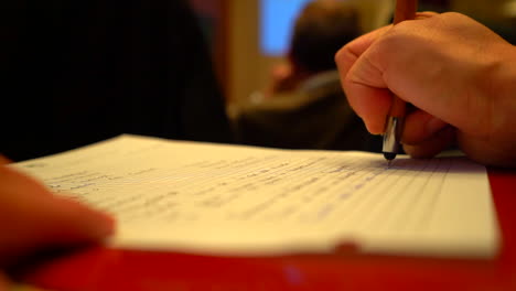 depth of field close up of hand taking notes in conference