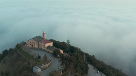 Drohne,-Die-über-Den-Wolken-Fliegt,-Und-Eine-Kirche-Mit-Kreisbewegung