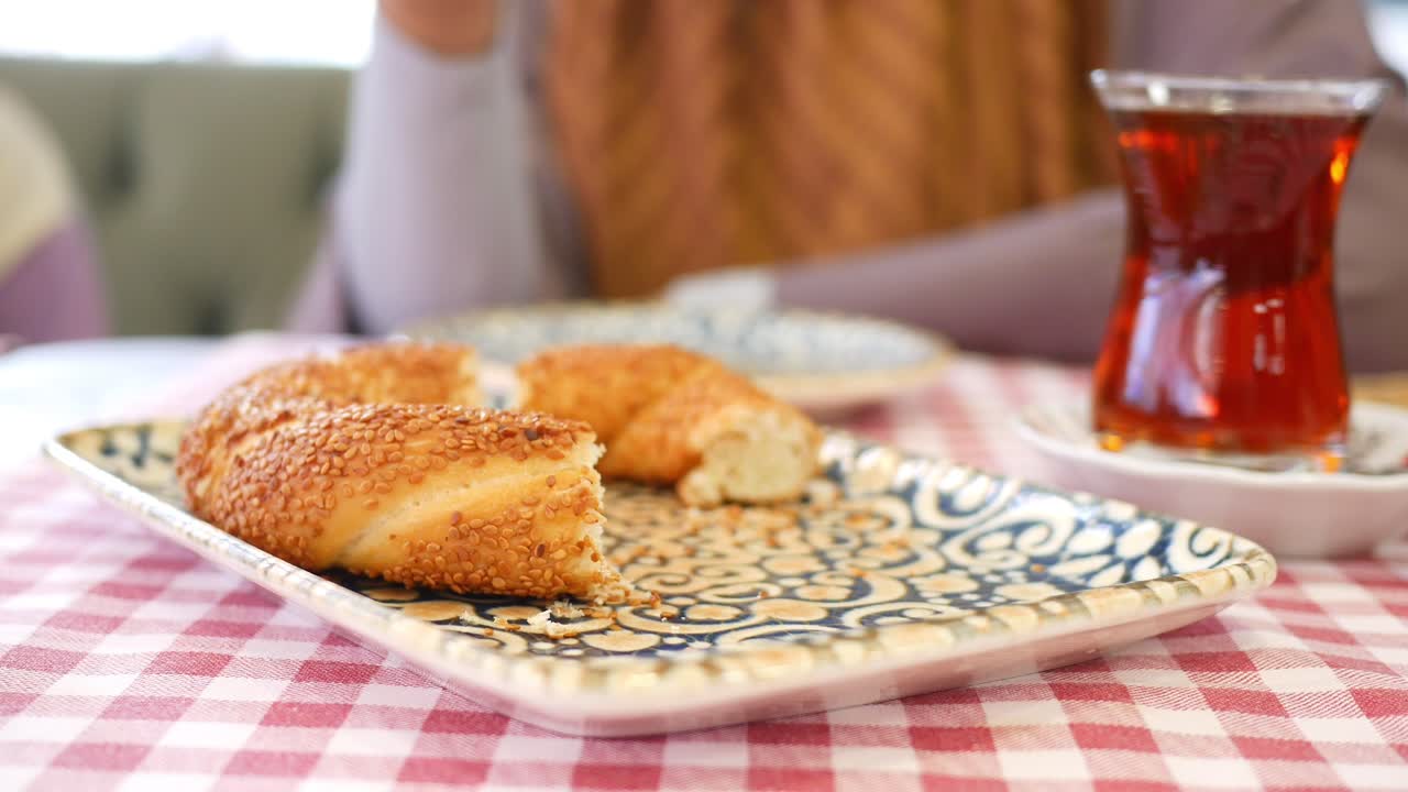 persona comiendo simit turco con té