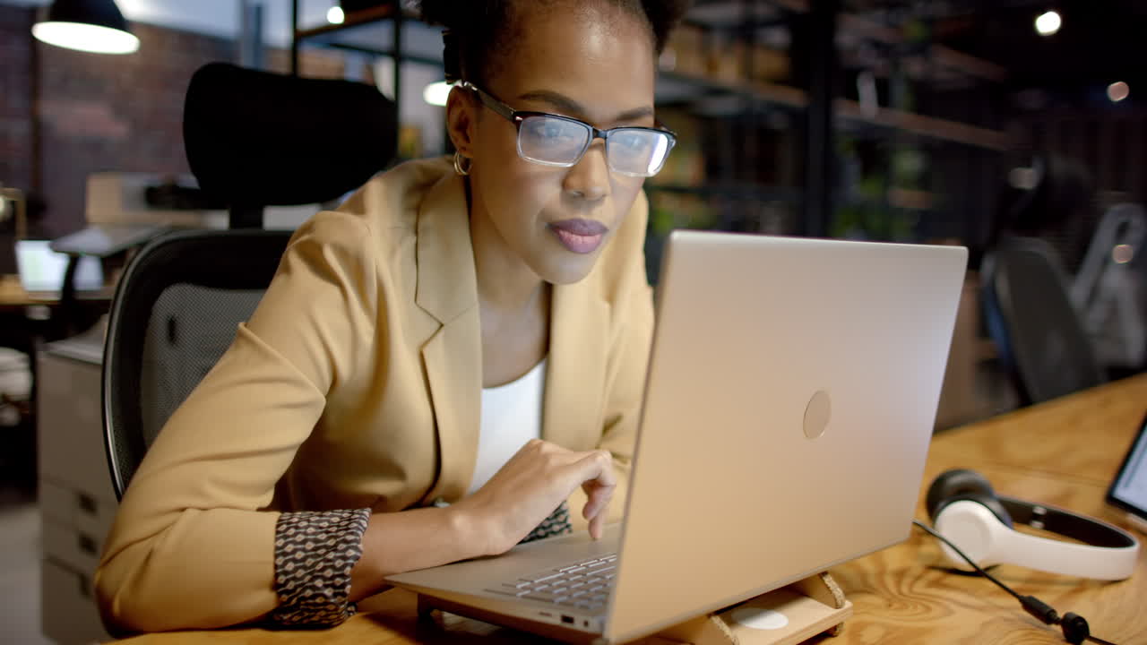 Young African American woman works intently on a laptop in a business office