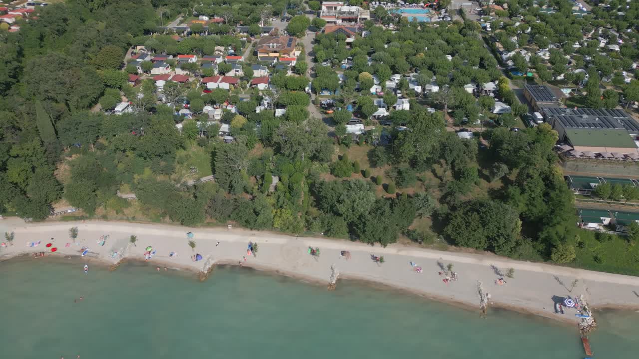 vista aérea de la playa y el campamento de fossalta en la orilla del lago de garda, italia