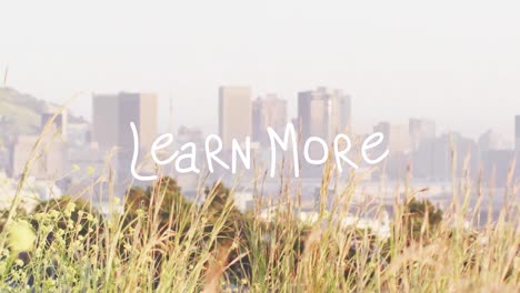 animation of learn more text banner against grass and view of cityscape