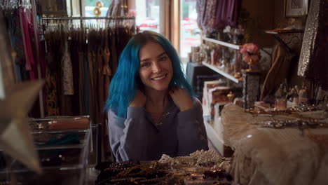 young woman with blue hair trying on jewelry in a boutique