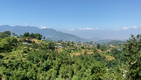 Una-Vista-De-Un-Pequeño-Pueblo-En-La-Cima-De-Una-Colina-Con-Las-Montañas-Del-Himalaya-En-El-Fondo-Con-Una-Vista-Panorámica