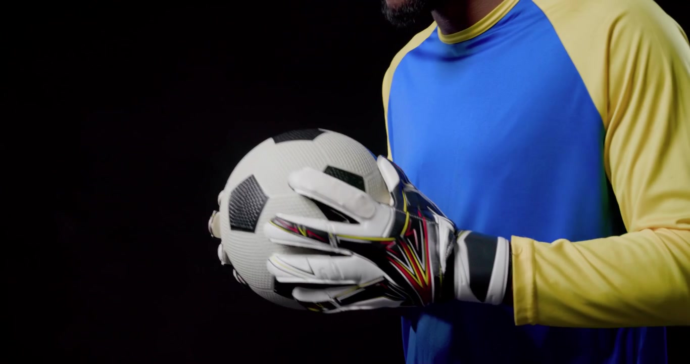 グローブをはめたキーパーがサッカーボールを掴み、スピンエフェクトが開始され、ウォーミングアップのために回転させてキャッチする。