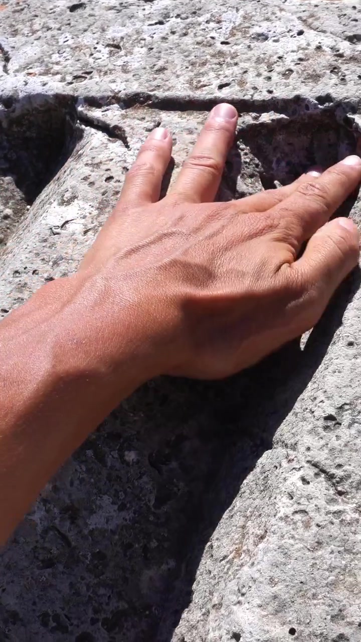 Hand touching an ancient greek column ruin