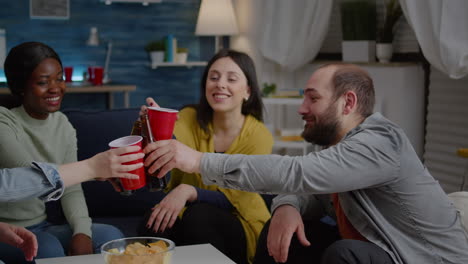 amigos multirraciales riendo mientras disfrutan de una fiesta nocturna bebiendo cerveza