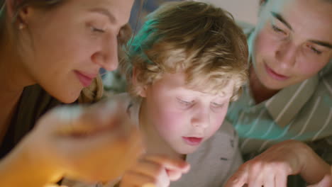 lesbian parents and kid reading bedtime story on tablet